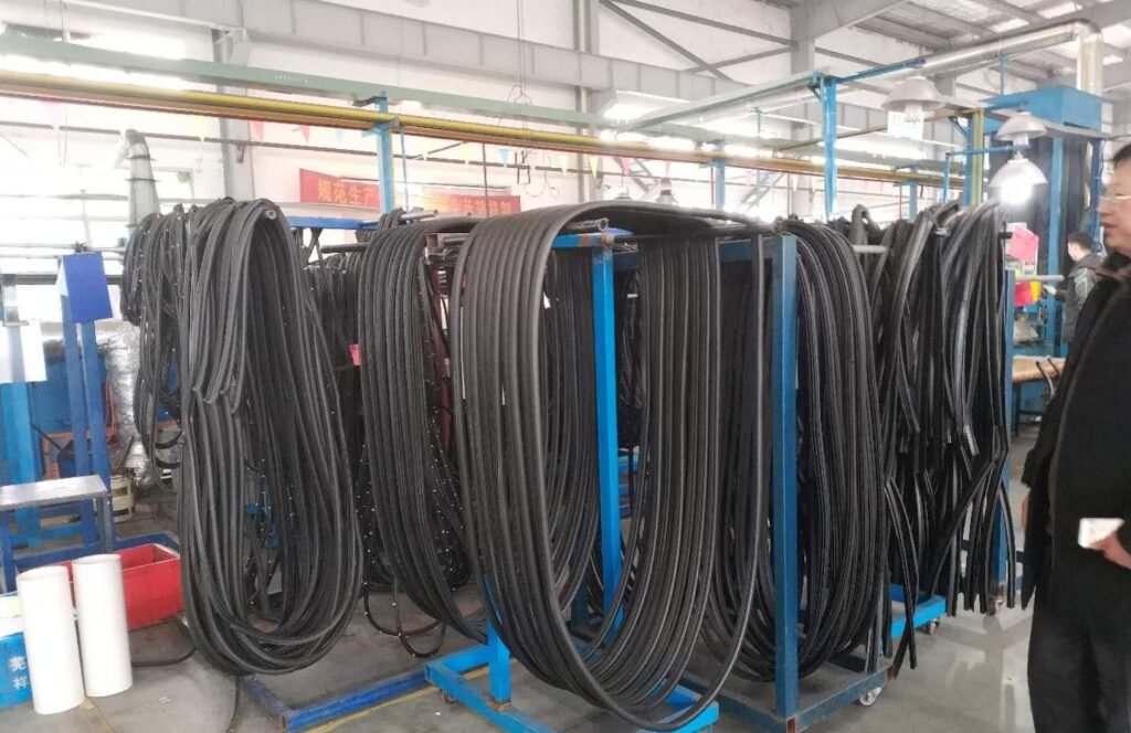 Racks of freshly extruded black rubber sealing profiles at the COi factory