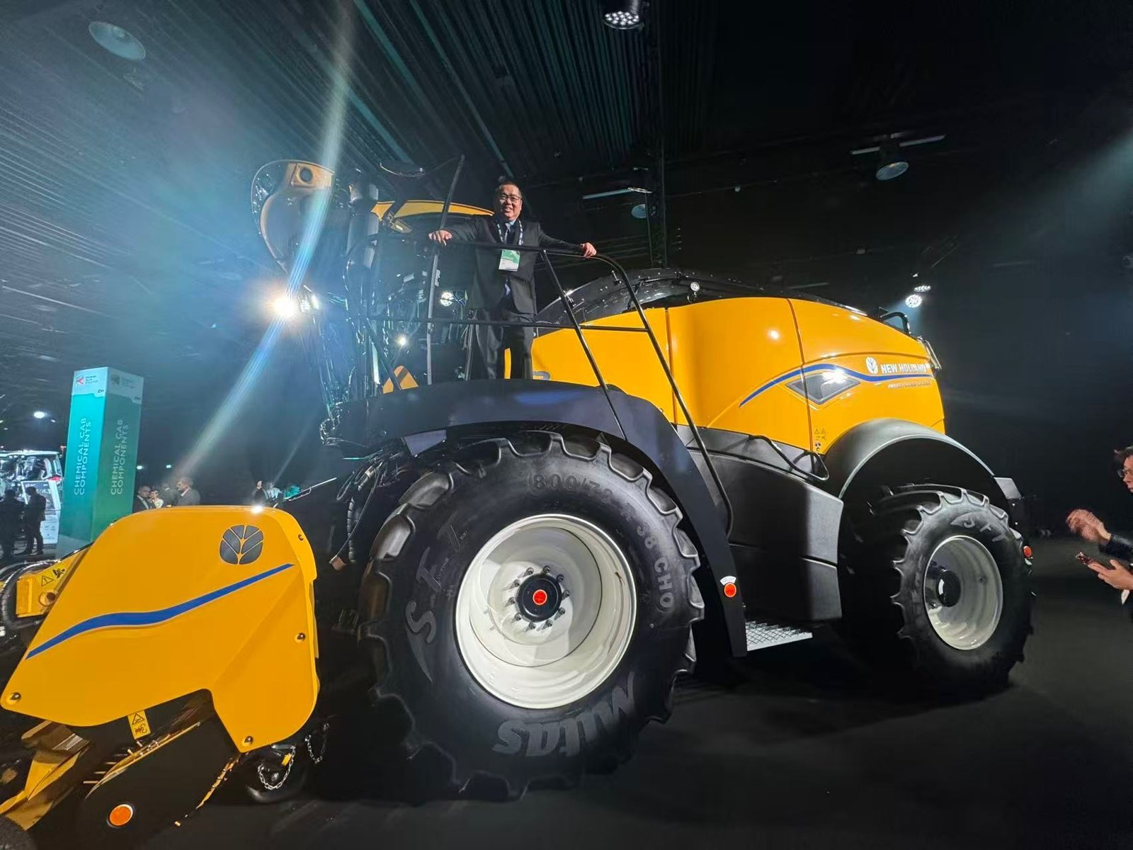 David Chao at a trade show in front of an agricultural harvester