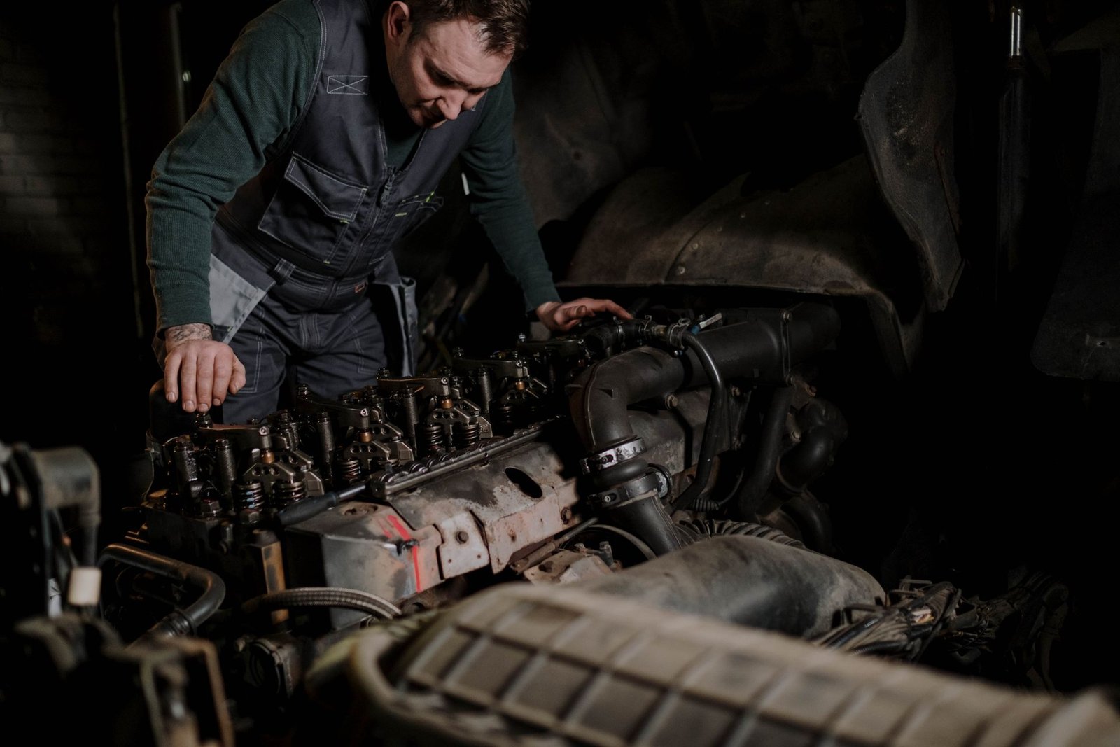 Mechanic working on a heavy truck engine (stock photo, illustrative)