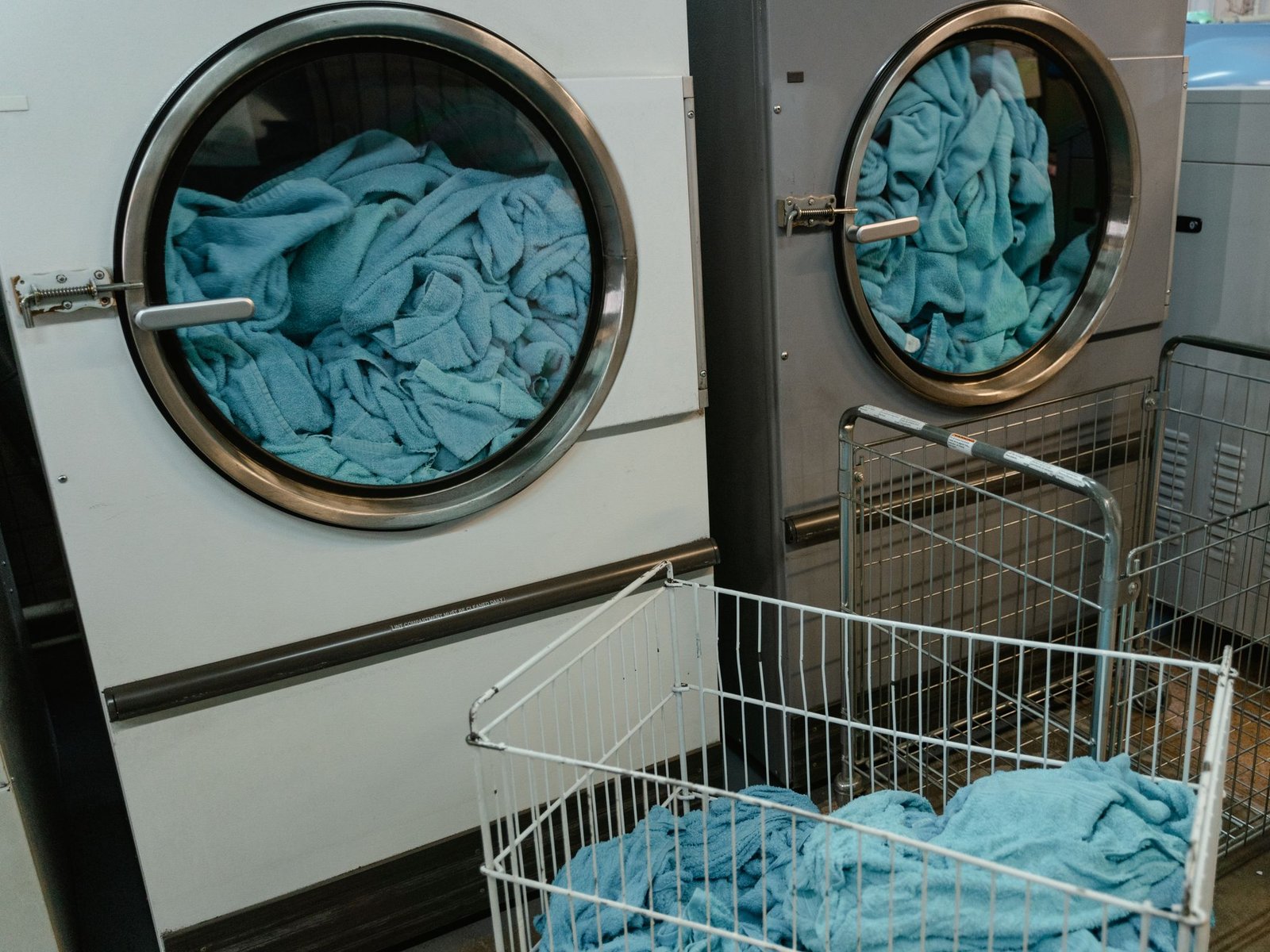 Commercial laundry dryers with linen (stock photo, illustrative)